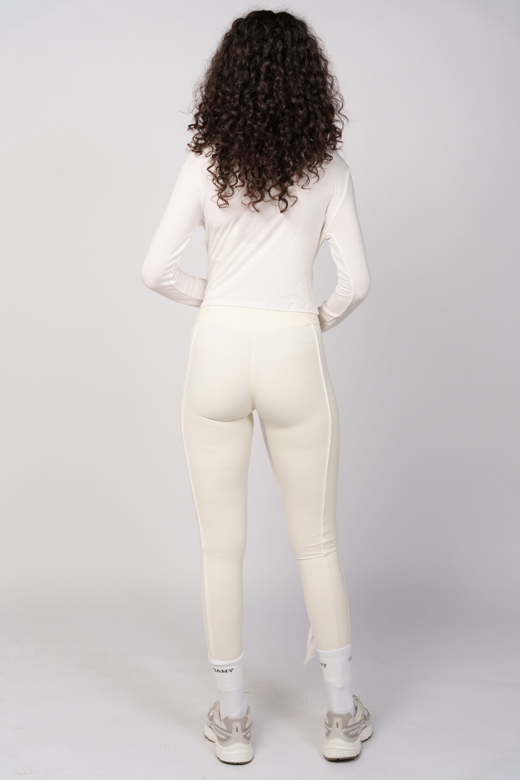 Person wearing a white jumpsuit on a plain background