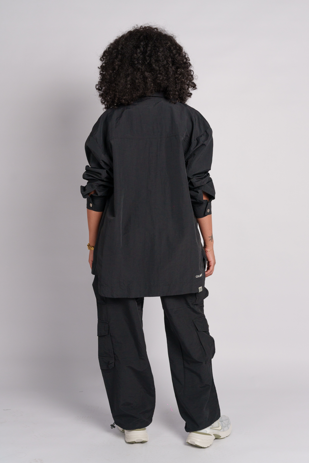 Person wearing a black shirt and black cargos.