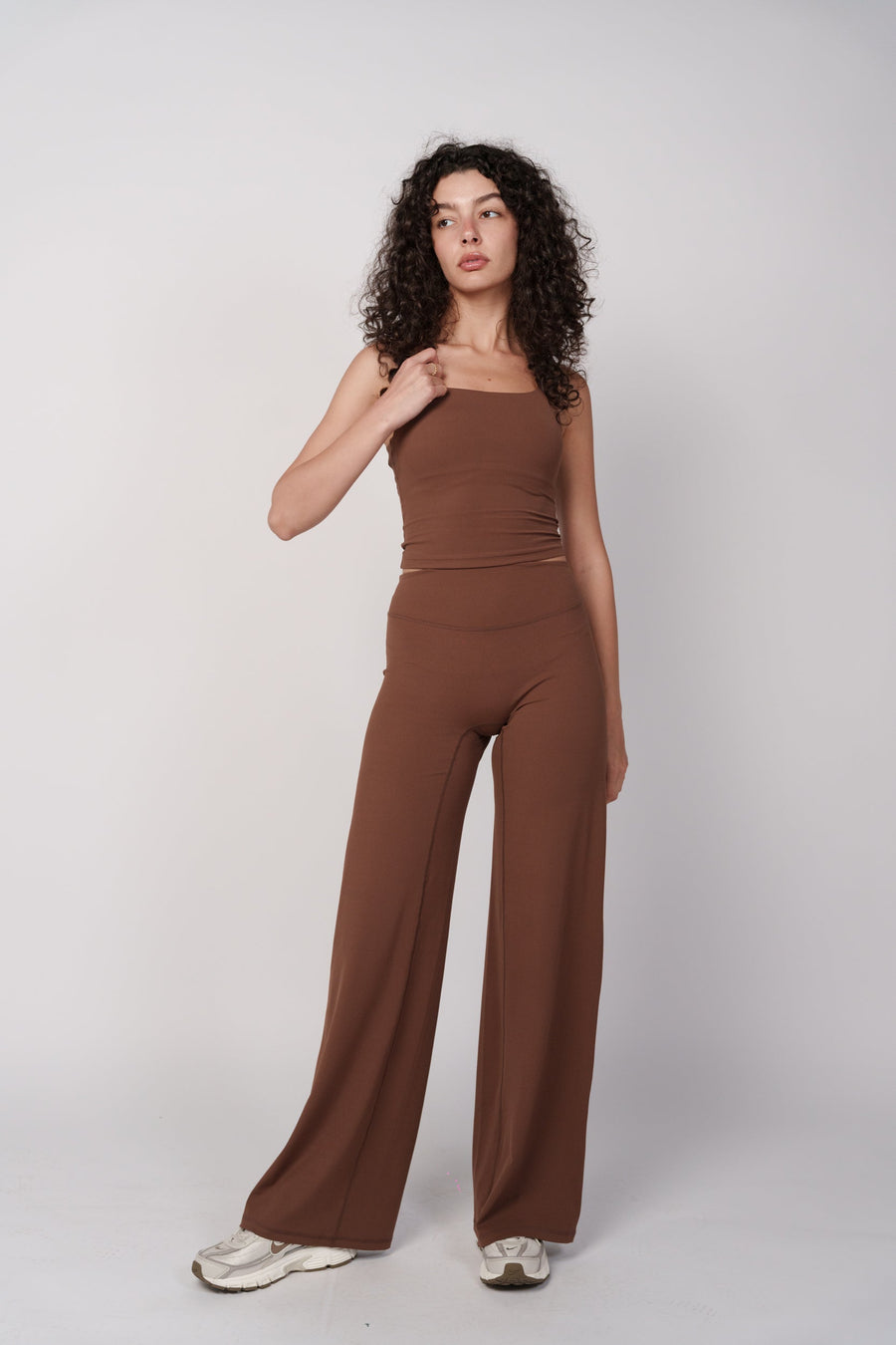 OAMY Wide Flare Pants in brown, shown full-length on model with a fitted top to demonstrate the wide-leg silhouette
