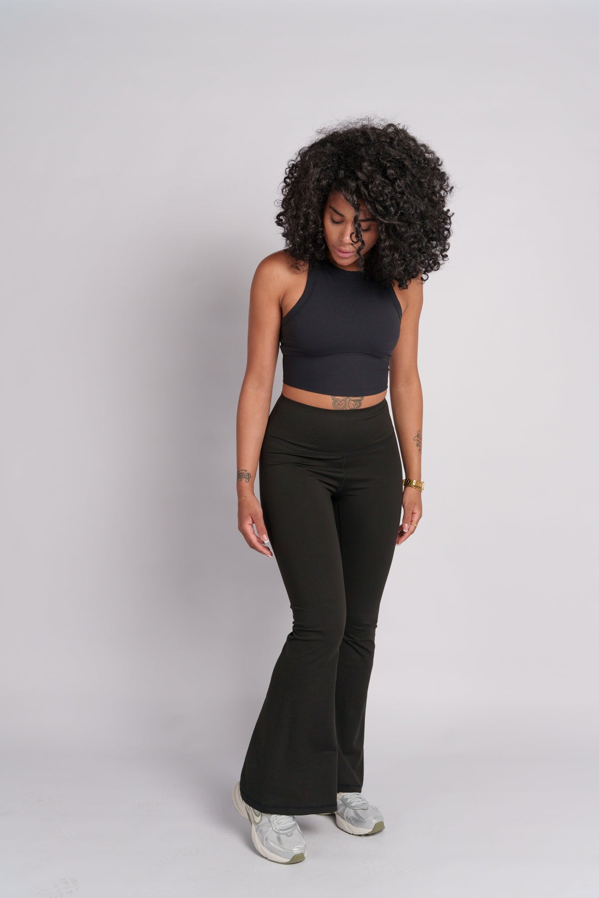 Woman wearing a black crop top with black flared pants.