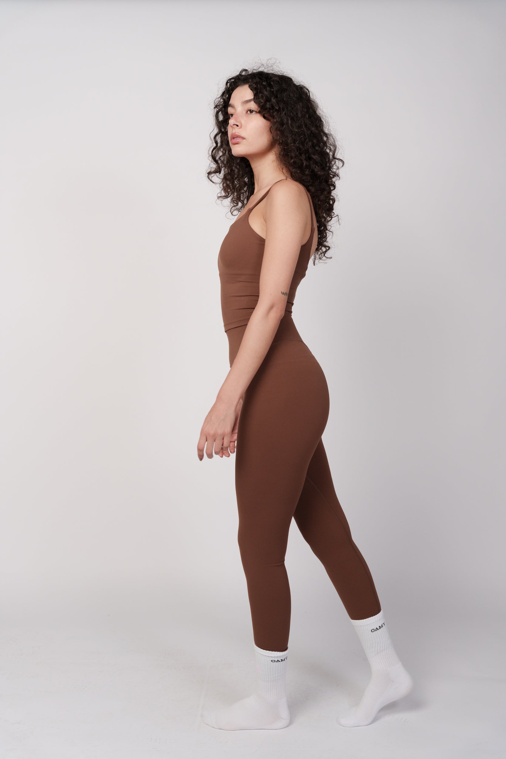 Woman wearing a brown jumpsuit on a white background