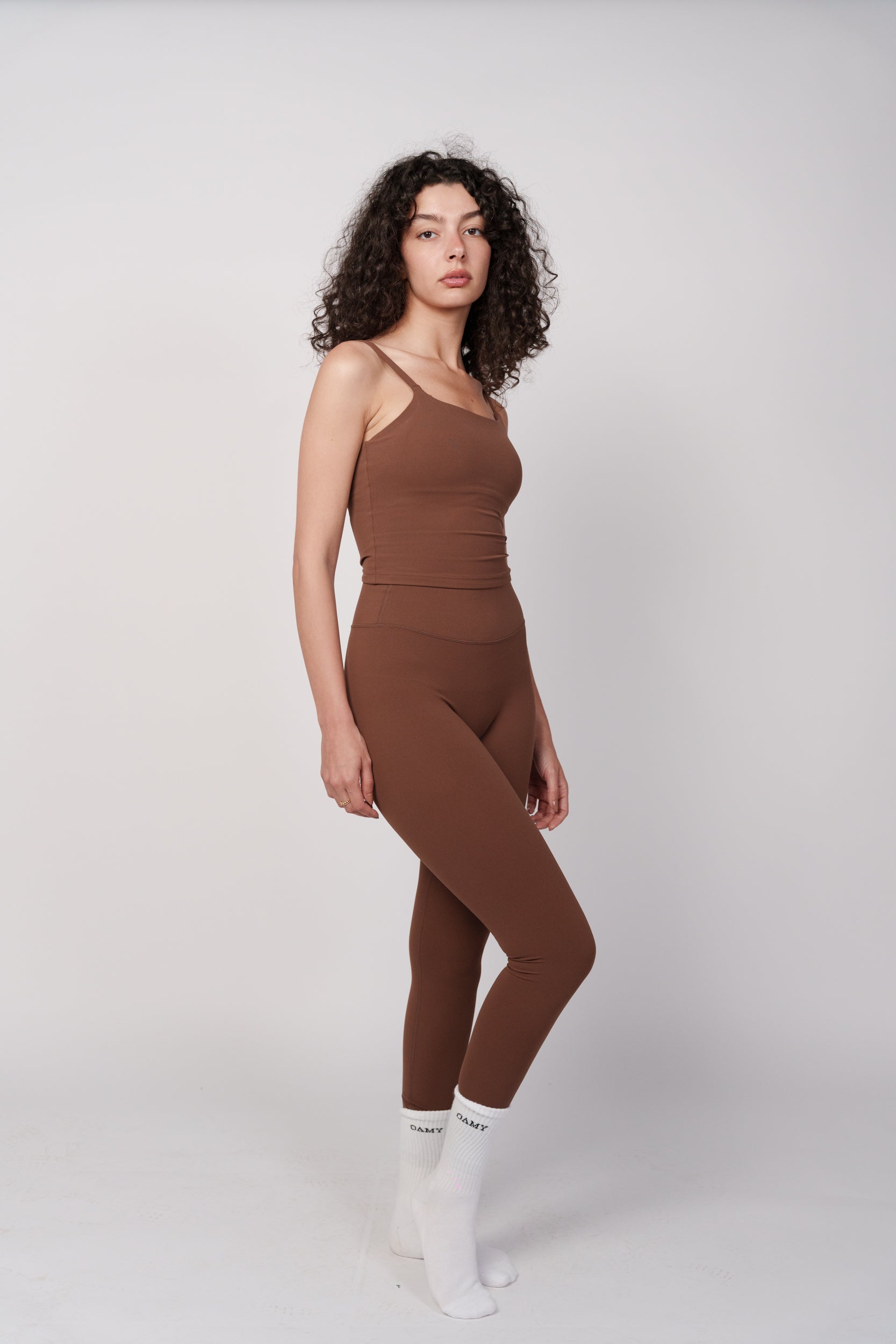 Woman wearing a brown jumpsuit on a white background