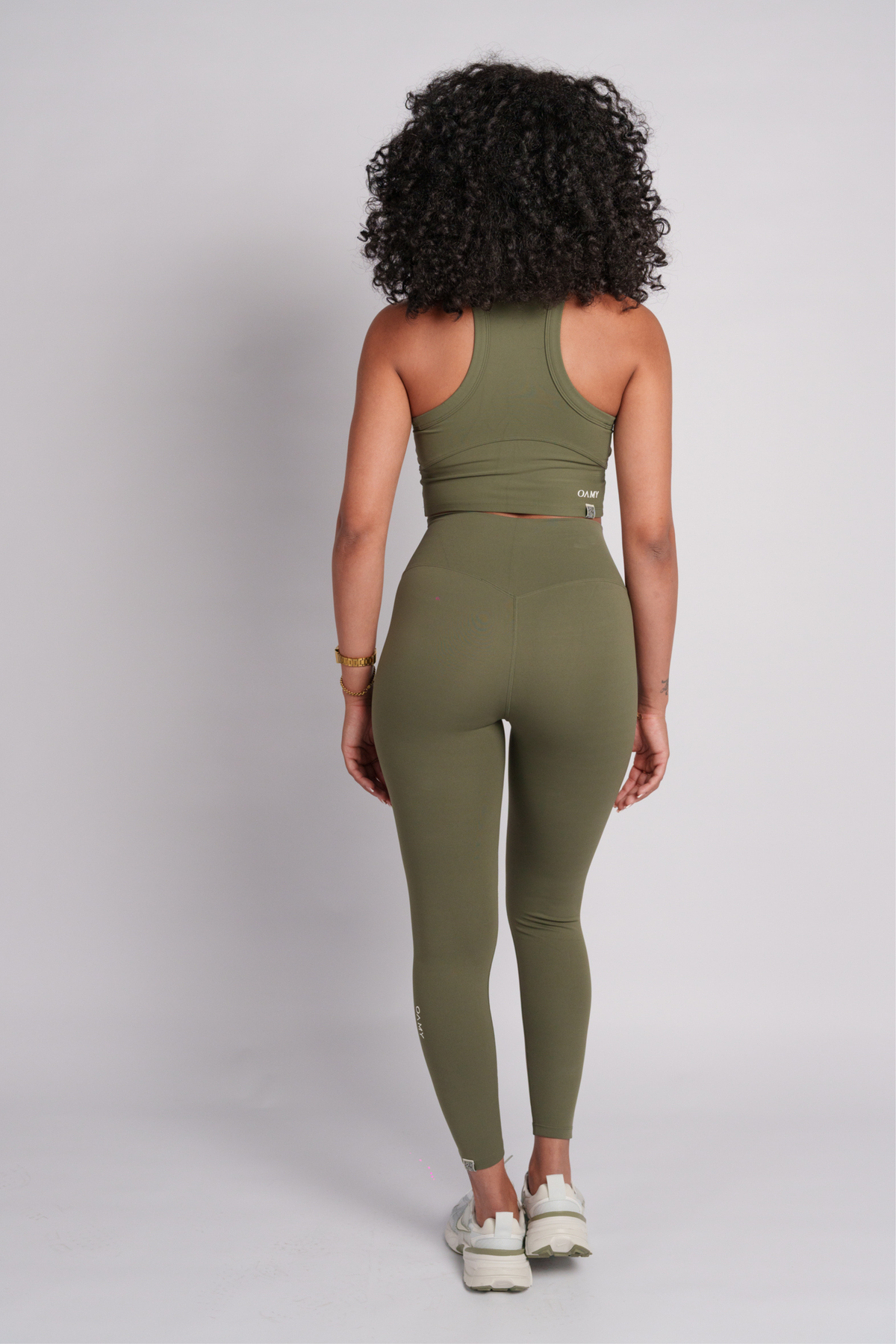 Woman wearing a green olive crop top and leggings.