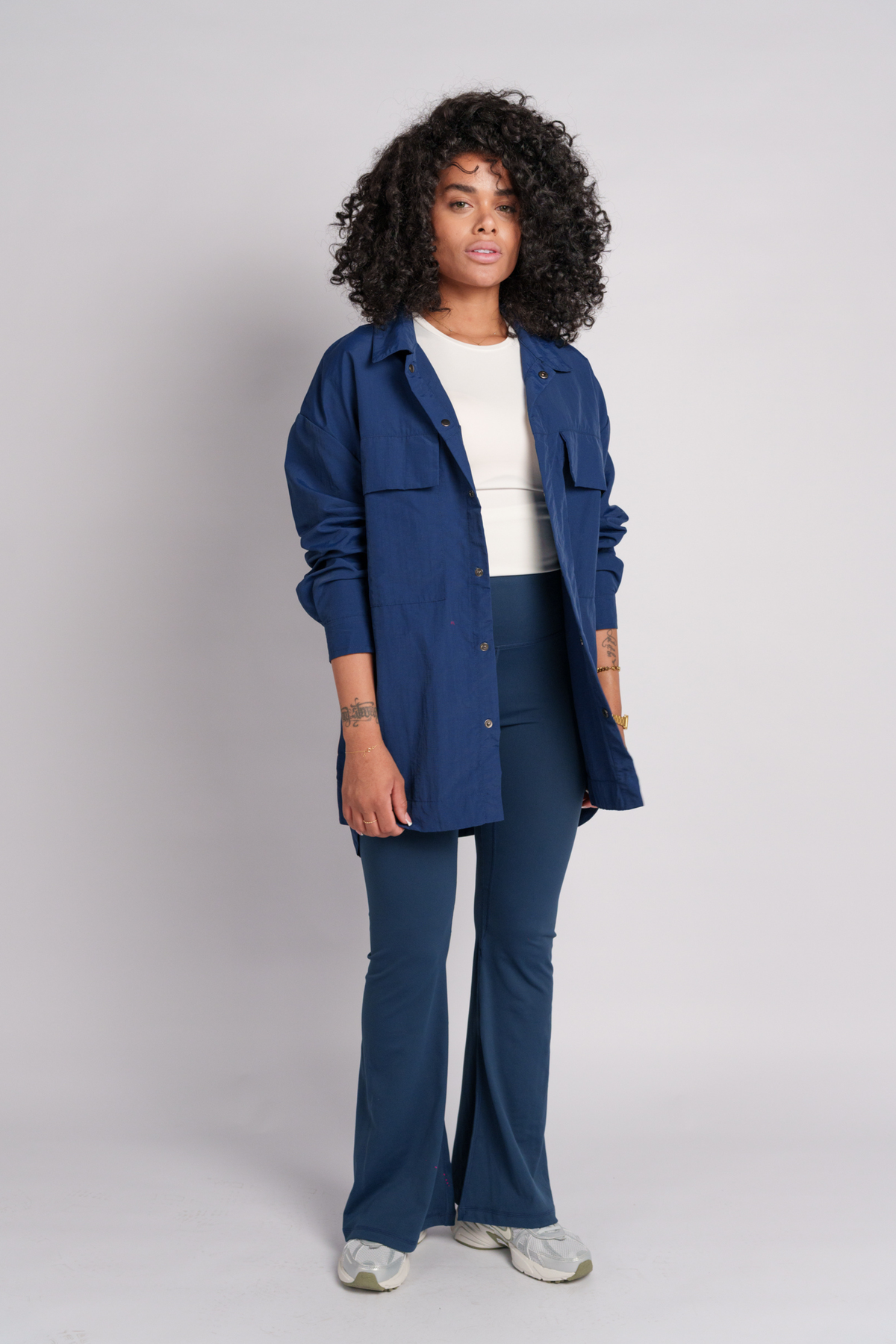 Woman wearing a navy shirt and flare pants.