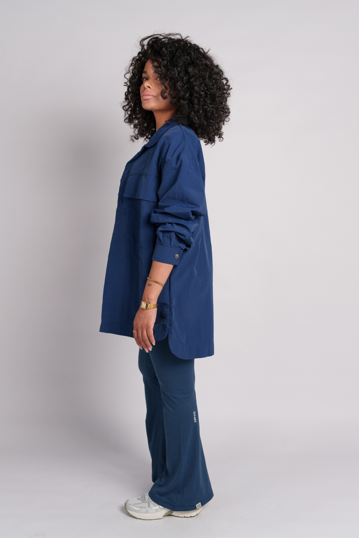 Woman wearing a navy shirt and flare pants.