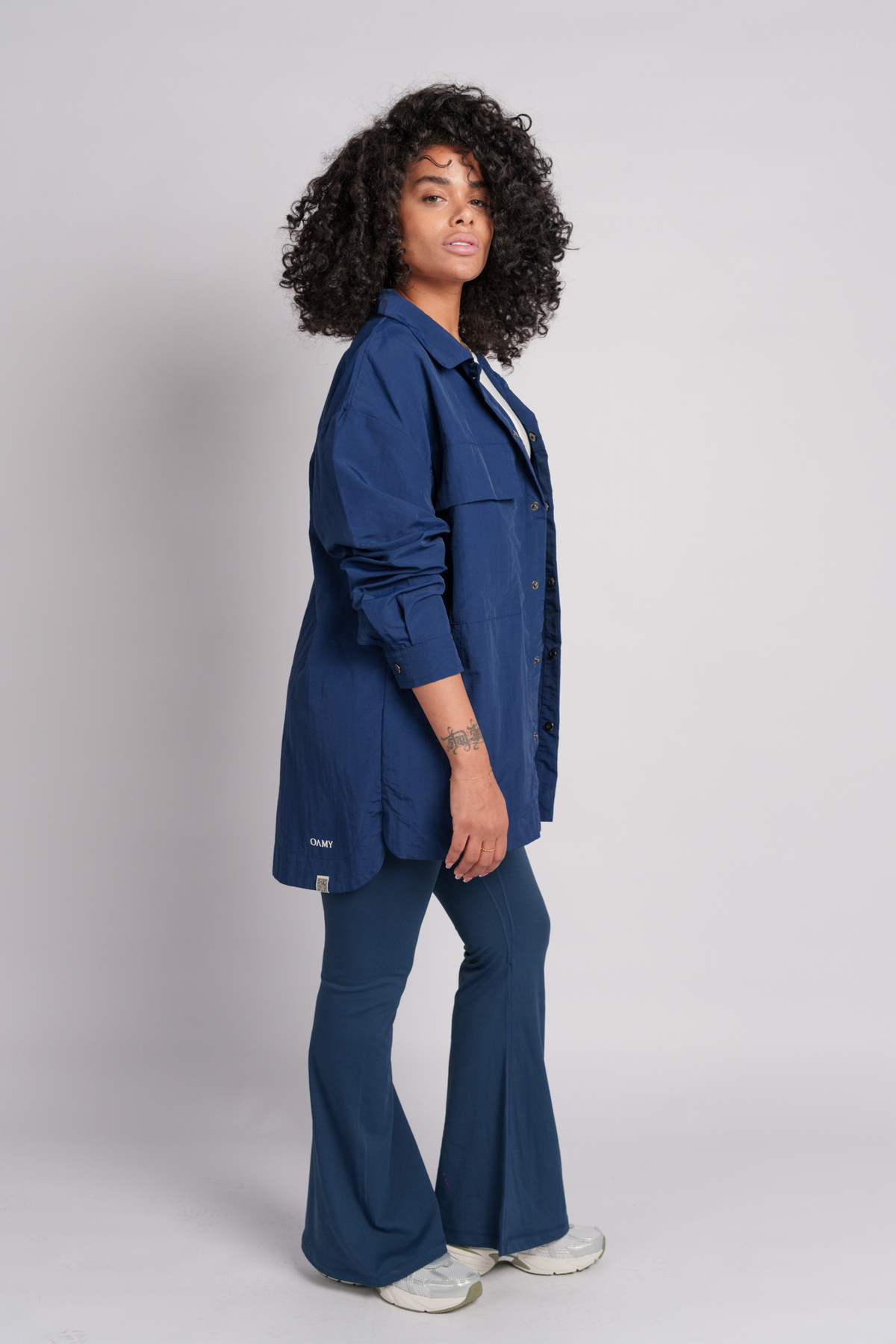 Woman wearing a navy shirt flared pants.