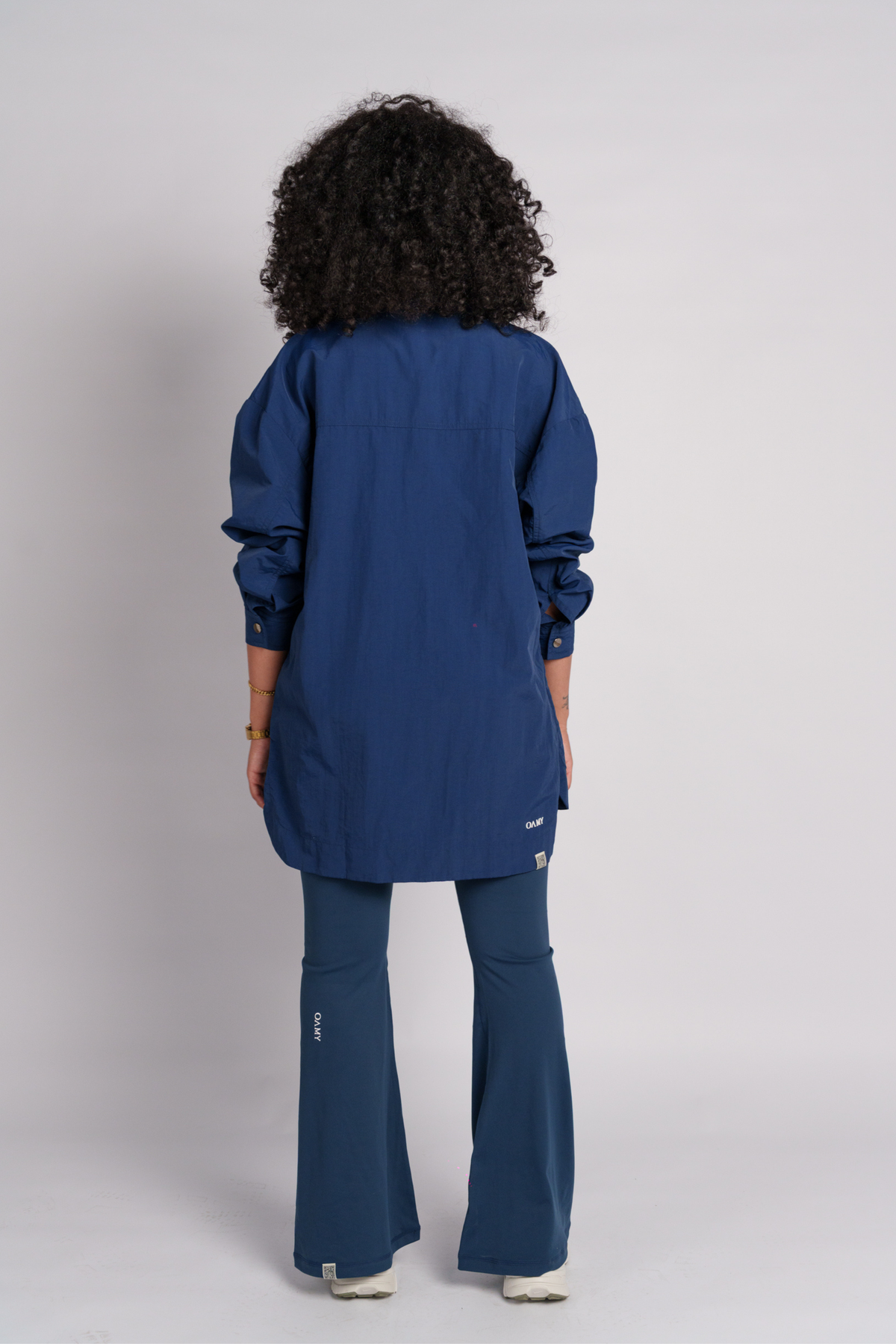 Woman wearing a navy shirt and flare pants.