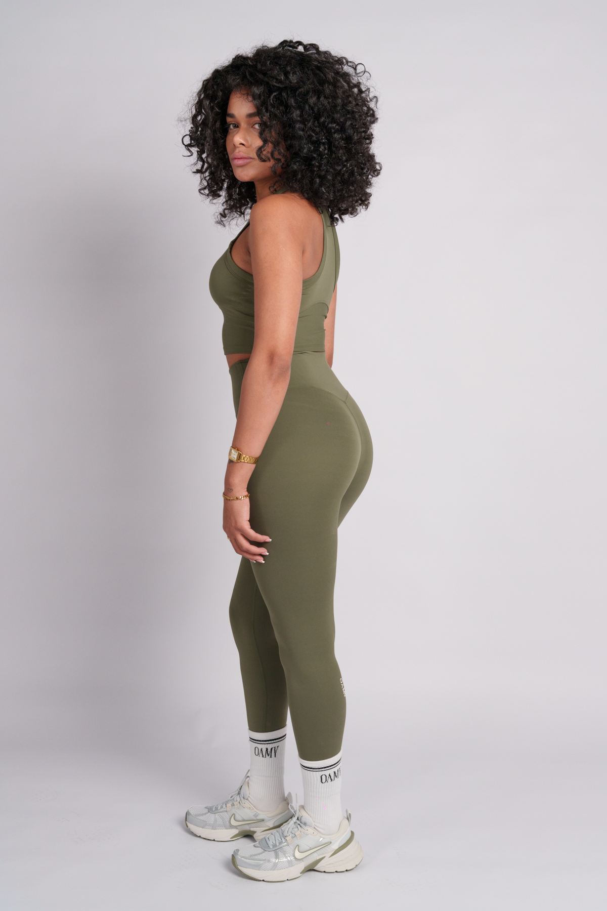 Woman wearing a green olive crop top and leggings.