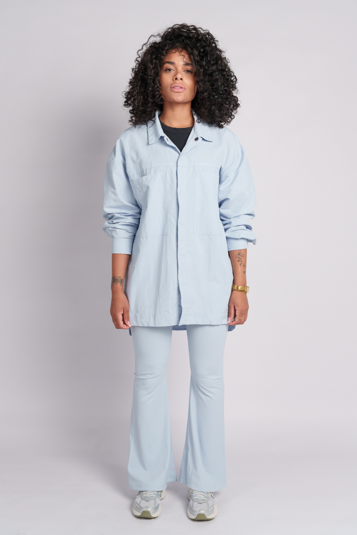 Person wearing a light blue shirt and flares