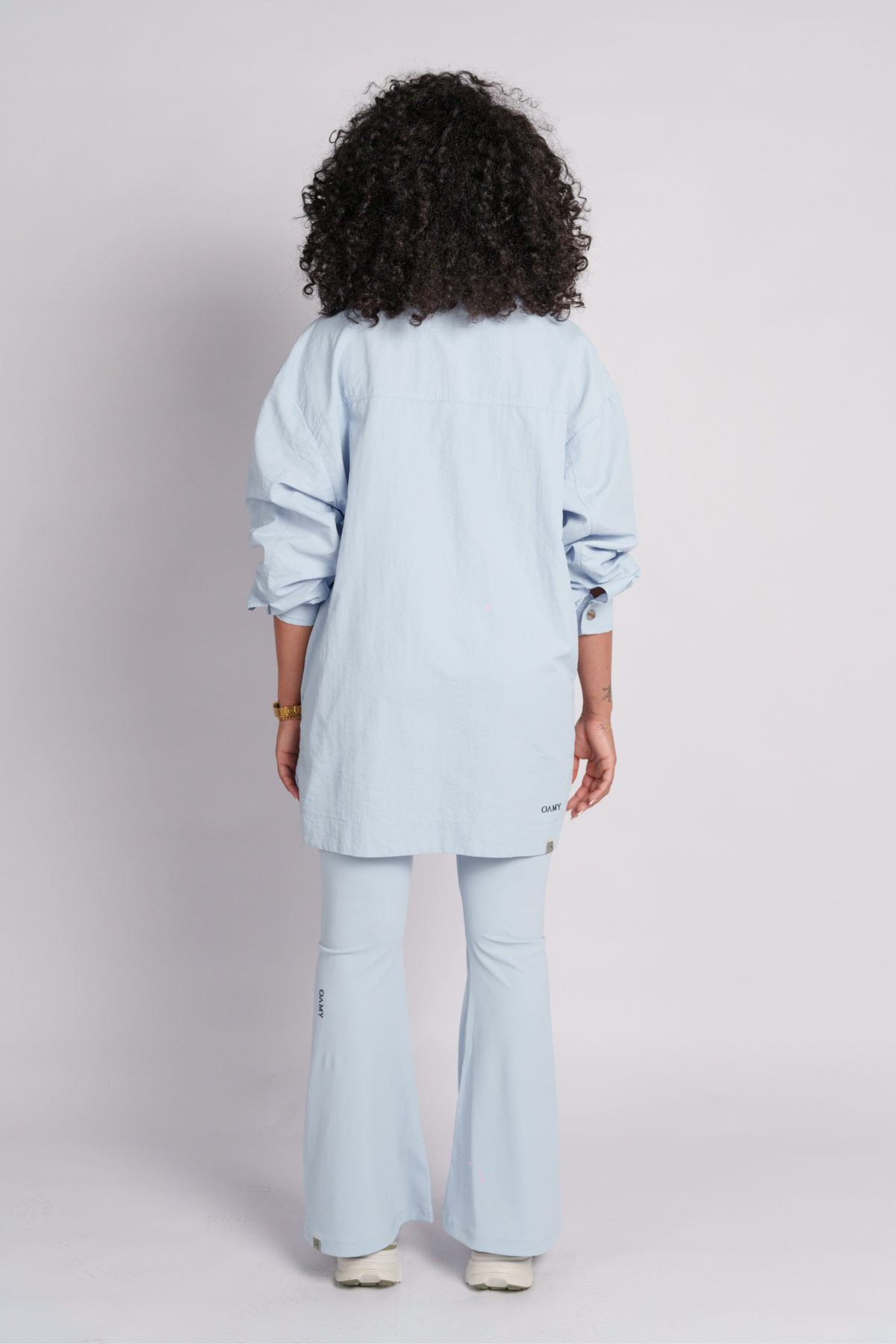 Woman wearing a baby blue shirt and flared pants.