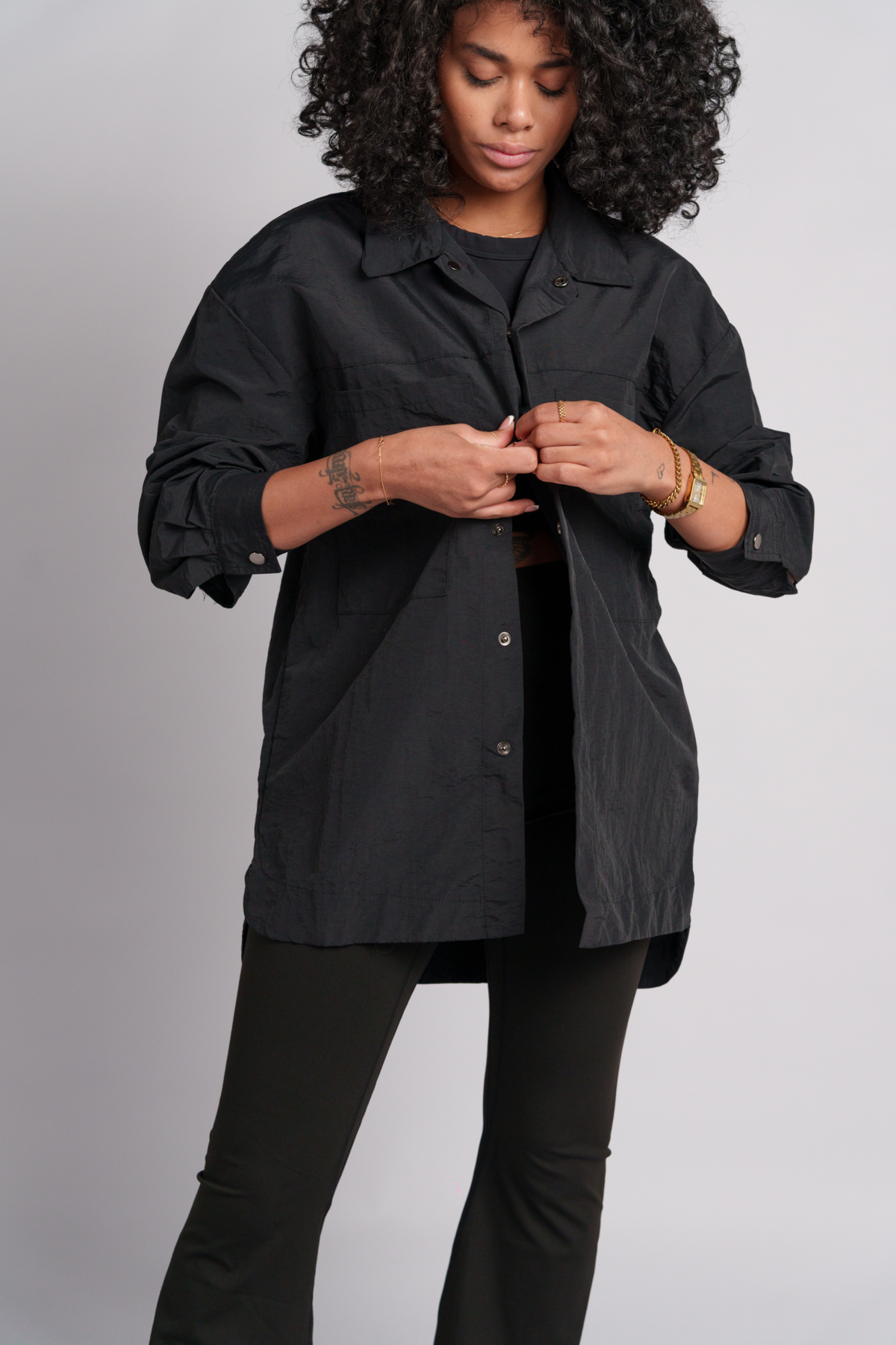Person wearing a black shacket with black flares and black crop top.