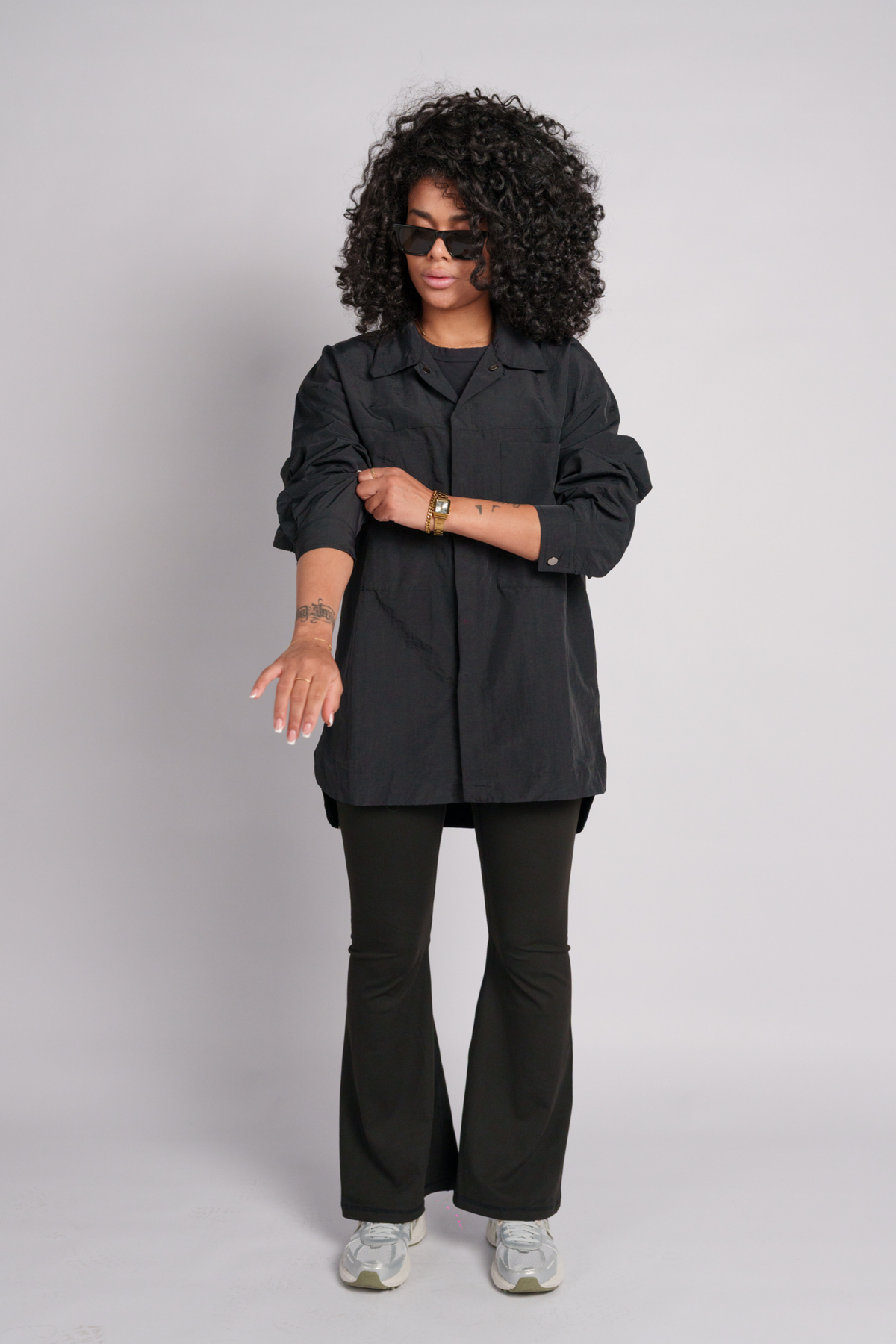 Woman wearing a black shacket with a black flare and a black crop top.