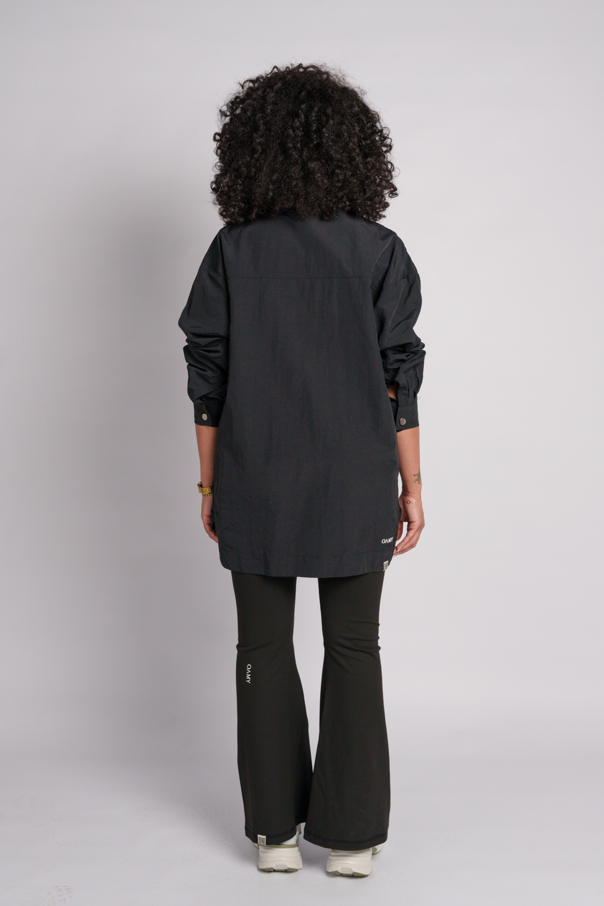 Person wearing a black shirt and flares.