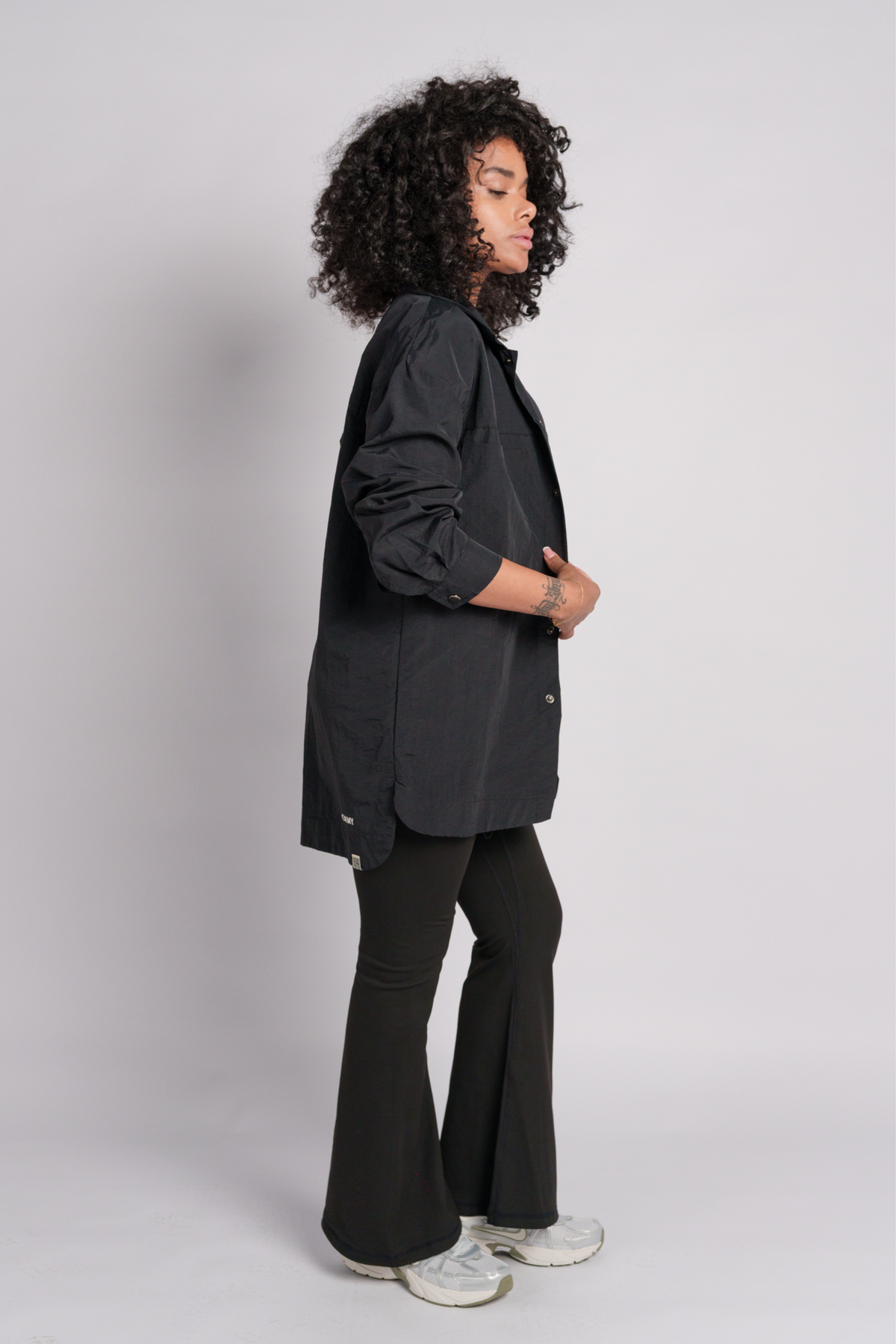 Woman wearing a black shacket with a black flare.